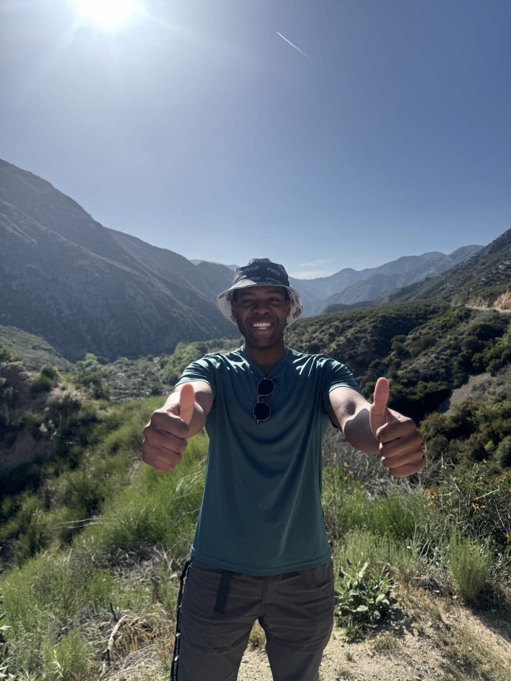 Chiemeka giving two thumbs up on a mountain trail